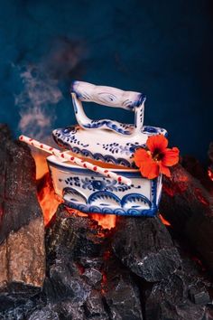 a blue and white dish sitting on top of a fire