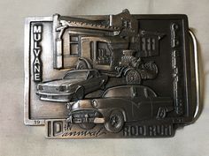 a metal belt buckle with an image of two cars on the front and back of it