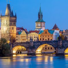 the old city is lit up at night with lights on it's buildings and bridges