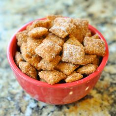 a small red bowl filled with sugar cubes on top of a granite countertop