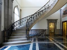 a staircase in an old building with marble floors