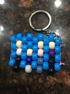 a blue and white beaded keychain sitting on top of a table