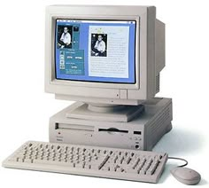 an old desktop computer sitting on top of a white table next to a keyboard and mouse