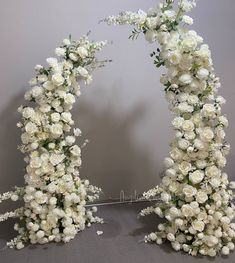 two white flowers are arranged in the shape of an arch for a wedding ceremony decoration