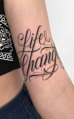 a woman with a tattoo on her arm that says life is change in cursive writing