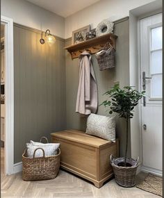 a wooden bench sitting next to a potted plant on top of a hard wood floor