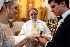 the bride and groom are exchanging their wedding rings at the alter in front of the priest