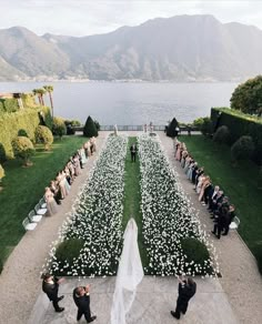 a bride and groom standing in front of an outdoor ceremony with flowers on the ground