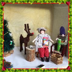 a group of dolls sitting next to each other in front of a christmas tree and decorations