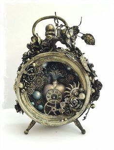 an ornate clock with flowers and other things on it's face, sitting in front of a white background