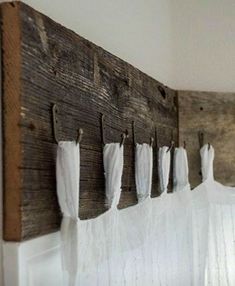 an old wooden coat rack with white towels hanging from it's hooks on the wall