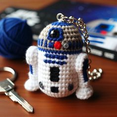 a crocheted star wars character keychain with a ball of yarn in the background