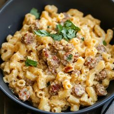 a black bowl filled with pasta and meat