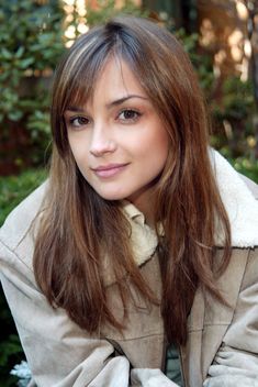 a woman with long hair sitting on a bench