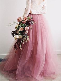 a woman in a pink tulle skirt holding flowers