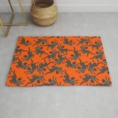 an orange area rug with black flowers on it