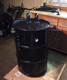 a large black barrel sitting on top of a wooden table