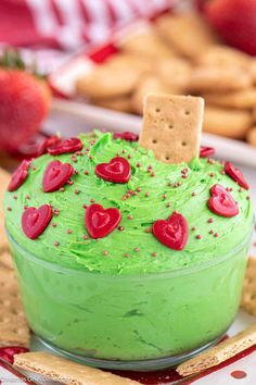 a green cake with red hearts and crackers on top