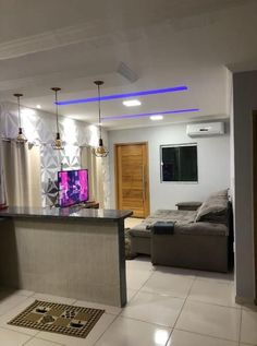 a living room filled with furniture and a flat screen tv on top of a counter