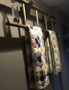 three quilts are hanging on the clothes rack