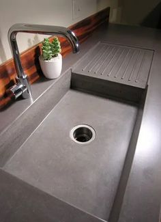 a sink in a bathroom with a potted plant on the counter next to it