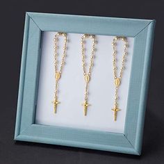 three cross necklaces in a blue frame