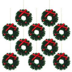 six christmas wreaths with red bows hanging from strings