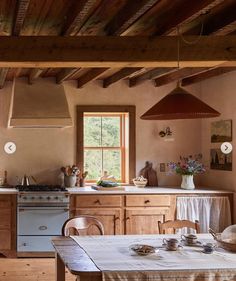 a kitchen with an oven, stove and dining table in the middle of the room