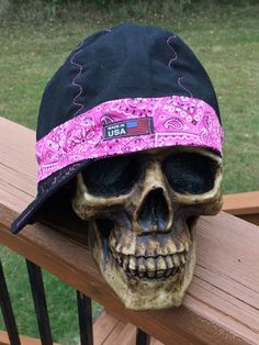 a skull wearing a hat on top of a wooden bench