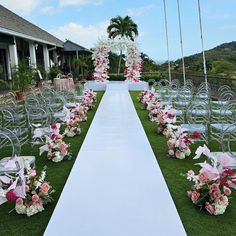 an outdoor ceremony setup with chairs and flowers on the grass, set up in front of a building