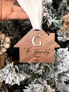 a wooden ornament with the letter g on it hanging from a christmas tree