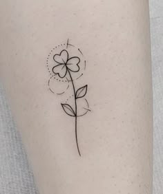 a small flower tattoo on the left side of the leg, it is black and white