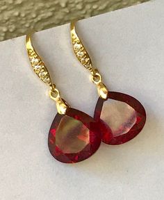 "Burgundy Garnet gold pave earrings. Heart cut garnets. Red stone jewelry. Red garnet dangles. Dark red garnet drops. Junuary birthstone. Available in 3 finishes. Length 1 1/4\". Dark red faceted gems are 14x14 mm as photo are sold, 19x14 mm and 13x17 mm stones are available. These beautiful earrings will arrive in a jewelry box ready for gift giving." Red Stone Jewelry, Pave Earrings, Garnet And Gold, Faceted Gems, Earrings Heart, Red Stone, Red Garnet, Stone Jewelry, Dark Red