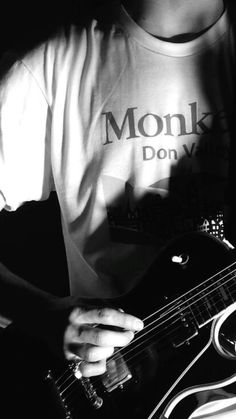 black and white photograph of a man playing an electric guitar