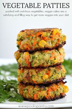 three crab cakes stacked on top of each other in front of some parsley leaves