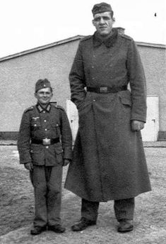 an old black and white photo of two men in uniforms standing next to each other