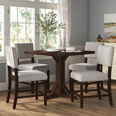 a dining room table with four chairs around it