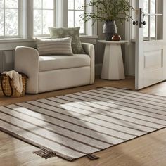 a living room with a couch, chair and rug