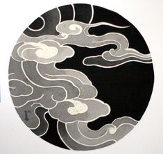 a black and white painting with clouds in the sky on a round plate, hanging on a wall