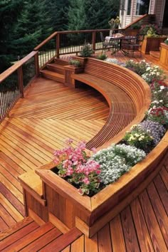 a wooden deck with plants and flowers on it