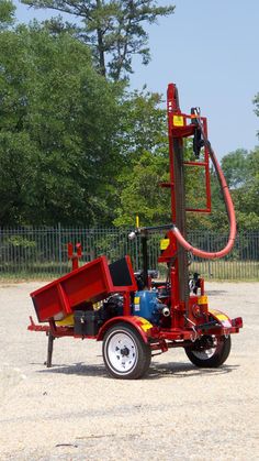 a small red truck with a hose attached to it's back