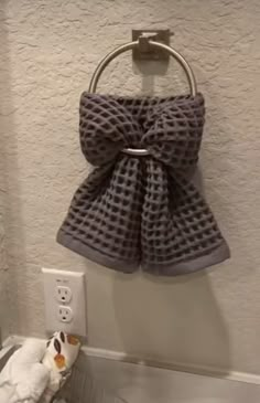 a towel hanging on the wall next to a sink with a stuffed animal in front of it