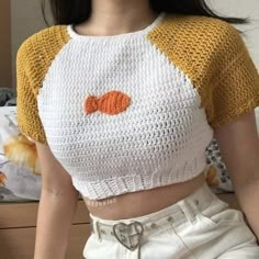 a close up of a person wearing a knitted shirt with an orange fish on it