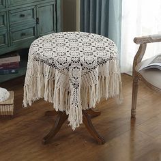 the table cloth has fringed tassels on it and is decorated with flowers