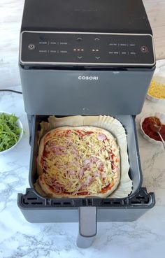 a pizza sitting inside of an oven on top of a counter next to other food