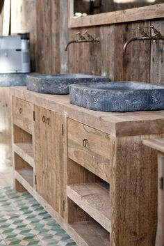 two stone sinks sit on top of an old wooden cabinet in a rustic style bathroom