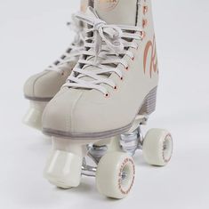 a pair of roller skates with white wheels on a plain surface, in front of a white background