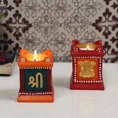 two small candles sitting next to each other on a table