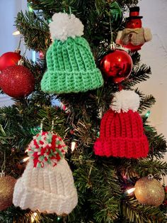 a christmas tree with knitted hats hanging from it