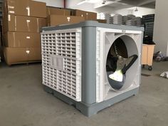 an industrial air conditioner sitting in the middle of a warehouse filled with cardboard boxes